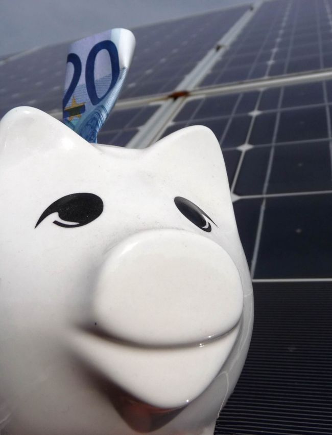 Sparschwein mit 20 Euro Schein vor Solaranlage (oder Photovoltaikanlage)